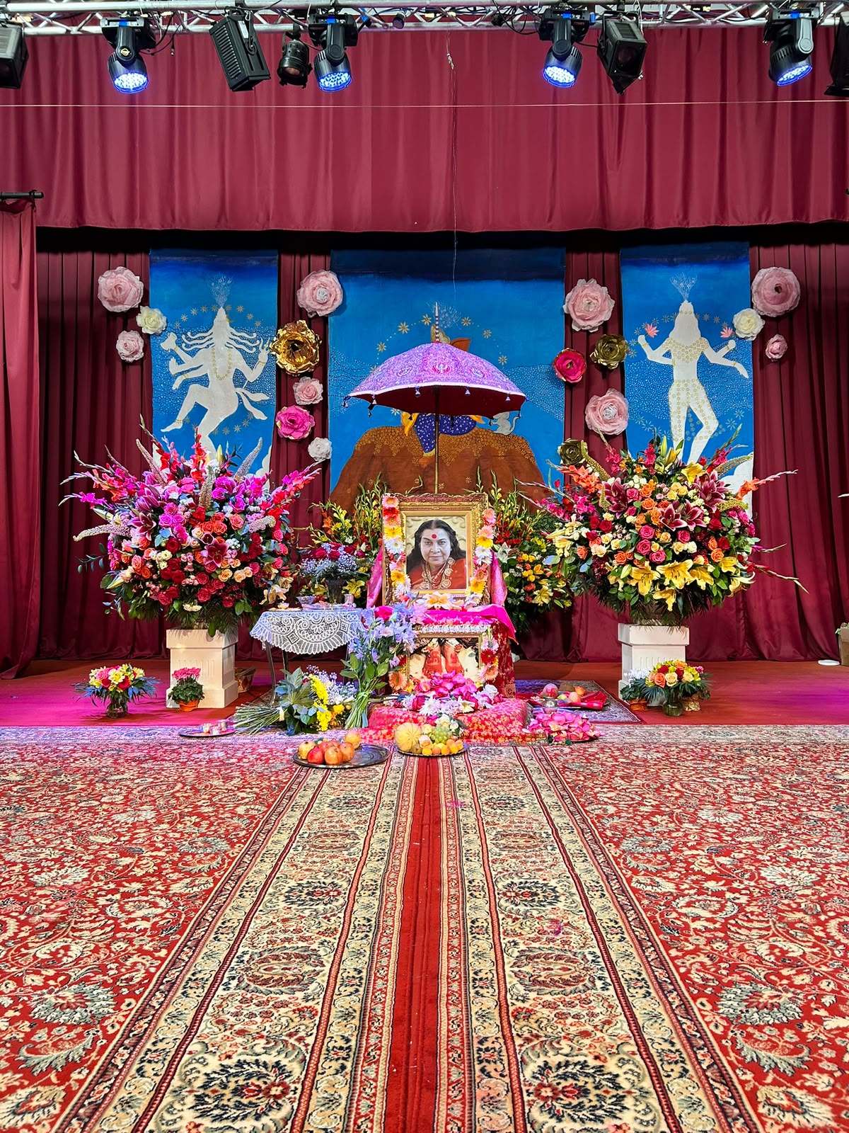 Flowers and Shri Mataji's photograph on the decorated stage in Cabella